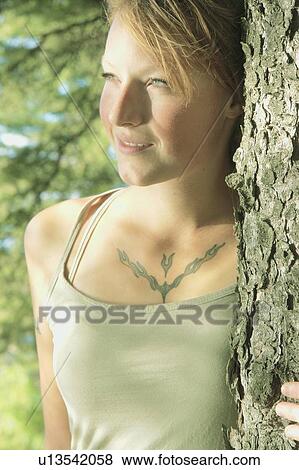 Stock Photo - Woman with arm around tree, in a grove of trees, Riding Mountain National Park, Manitoba, Canada. Fotosearch