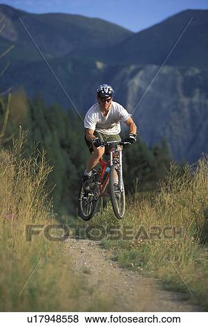 Stock Photo - Young man mountain biking on Wigwam Flats near Fernie, BC, Canada. Fotosearch