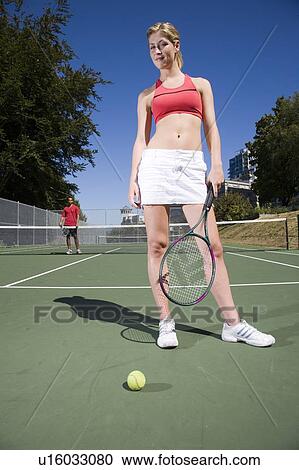 Stock Image - Couple on tennis court; Canada, British Columbia, Vancouver. Fotosearch
