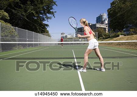 Stock Image - Couple playing tennis; Canada, British Columbia, Vancouver. Fotosearch