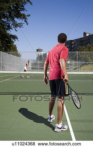 Couple playing tennis; Canada, British Columbia, Vancouver View Large Photo Image Stock Photo - Couple playing tennis; Canada, British Columbia, Vancouver. Fotosearch
