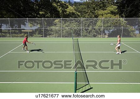 Couple playing tennis; Canada, British Columbia, Vancouver View Large Photo Image Stock Photo - Couple playing tennis; Canada, British Columbia, Vancouver. Fotosearch
