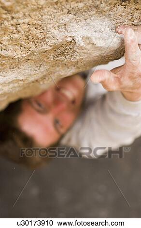 Man (20-25) stretching to grasp a rock ledge while rock climbing, Bishop, California, USA View Large Photo Image Stock Image - Man (20-25) stretching to grasp a rock ledge while rock climbing, Bishop, California, USA. Fotosearch