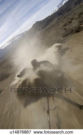 Stock Photo - Two men (20-30) surfing behind a car on a dirt road, Bishop, California, USA. Fotosearch