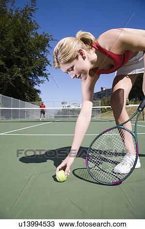 Stock Image - Woman readies to serve at tennis; Canada, British Columbia, Vancouver. Fotosearch
