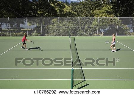 Stock Image - Young couple play tennis on public tennis courts, Vancouver, British Columbia. Fotosearch