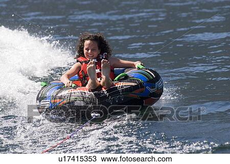 Young woman on inner tube behind boat, Okanagan Centre, BC Canada View Large Photo Image Stock Image - Young woman on inner tube behind boat, Okanagan Centre, BC Canada. Fotosearch
