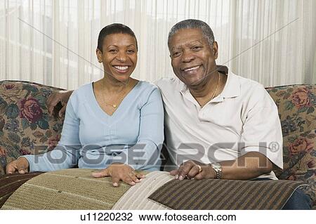 Stock Image - African American couple going over carpet samples, Vancouver, BC. Fotosearch