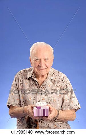 Stock Image - Senior male sitting; Canada, Saskatchewan, Regina. Fotosearch