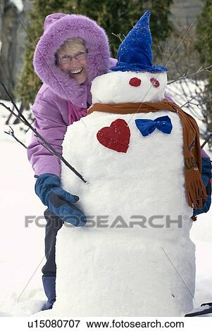 Senior woman embracing her snowman, Winnipeg, Canada View Large Photo Image Stock Photo - Senior woman embracing her snowman, Winnipeg, Canada. Fotosearch