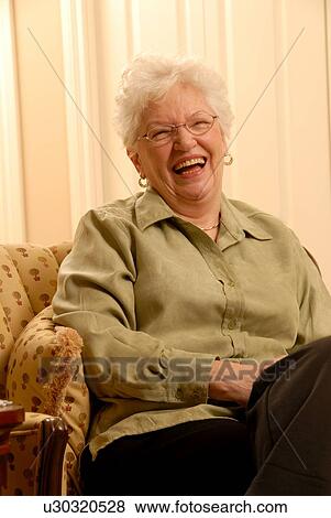 Stock Photo - Senior Woman in chair; Canada, Saskatchewan, Regina. Fotosearch