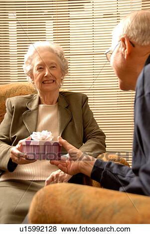 Stock Photo - Senior Woman with gift; Canada, Saskatchewan, Regina. Fotosearch