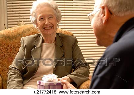 Stock Photo - Senior Woman with gift; Canada, Saskatchewan, Regina. Fotosearch