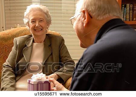 Stock Image - Senior Woman with gift, Regina, Saskatchewan. Fotosearch