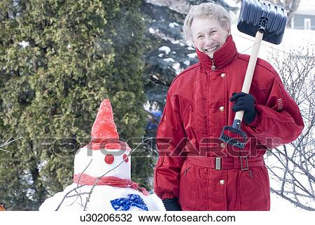 Senior woman with shovel beside snowmen, Winnipeg, Canada View Large Photo Image Stock Image - Senior woman with shovel beside snowmen, Winnipeg, Canada. Fotosearch