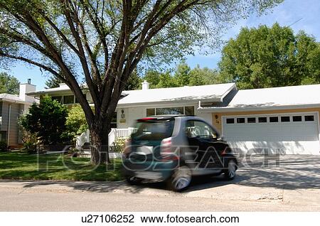 Stock Image - Blurred smart car pulling in & out of driveway, Regina, Saskatchewan. Fotosearch
