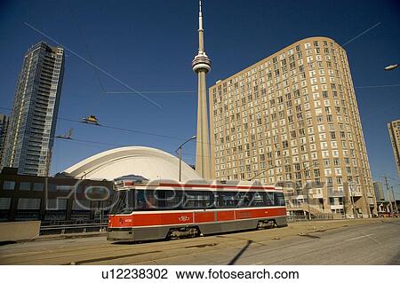 Stock Image - Streetcar in Toronto in front of CN Tower and Rogers Centre, formerly the Skydome. Fotosearch