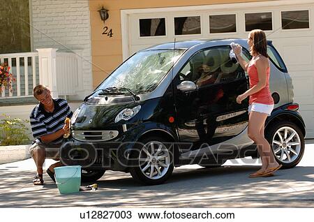 Stock Image - Teenage boy & girl washing smart car, Regina, Saskatchewan. Fotosearch