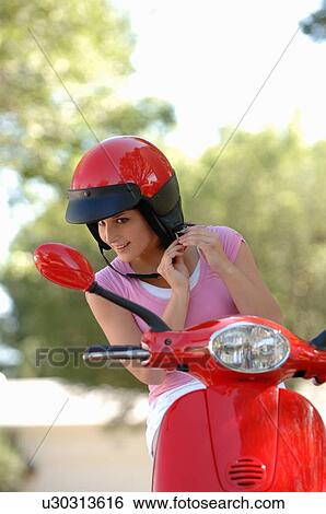 Young girl fastening helmet on red vespa, Regina, Saskatchewan View Large Photo Image Stock Photograph - Young girl fastening helmet on red vespa, Regina, Saskatchewan. Fotosearch