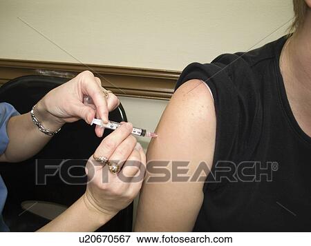 Stock Photo - A woman getting a flu shot. Fotosearch