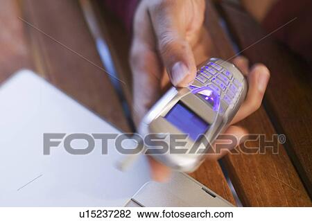 Stock Image - East Indian man and cellphone, West Vancouver, B. C.. Fotosearch