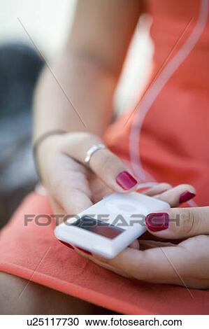 Stock Image - Female, 17, close up of ipod, Fraser River, Vancouver, BC. Fotosearch