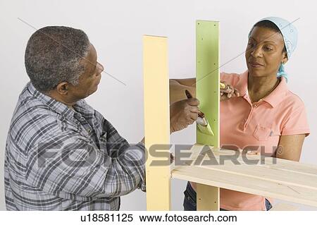 Stock Photography - African American Couple Doing Home Improvement Painting, Canada, British Columbia. Fotosearch