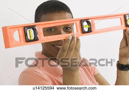 African American Woman Doing Home Improvement, Using a Spirit Level, B. C. View Large Photo Image Picture - African American Woman Doing Home Improvement, Using a Spirit Level, B. C.. Fotosearch