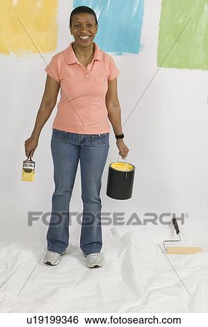 Stock Photograph - African American Woman Doing Home Improvement Painting, Canada, British Columbia. Fotosearch