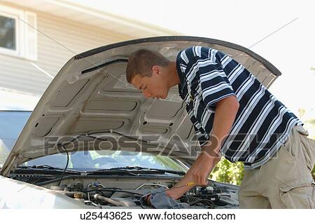 Stock Photography - Teenage boy checking oil, Regina, Saskatchewan. Fotosearch