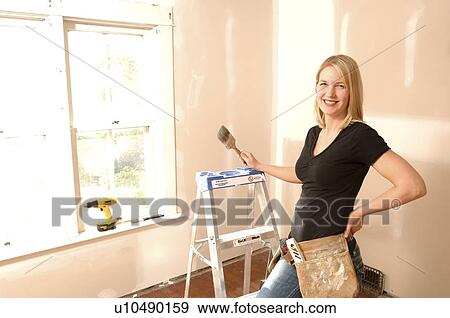 Woman holding paint brush, for home renovations View Large Photo Image Stock Photo - Woman holding paint brush, for home renovations. Fotosearch