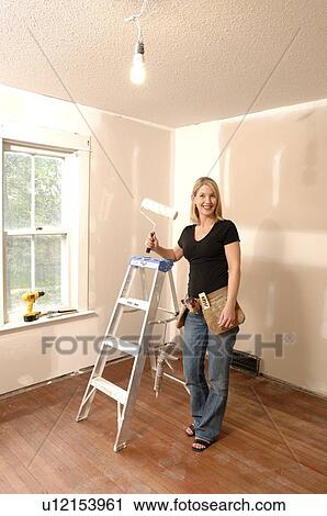 Woman holding paint roller, for home renovations View Large Photo Image Stock Image - Woman holding paint roller, for home renovations. Fotosearch