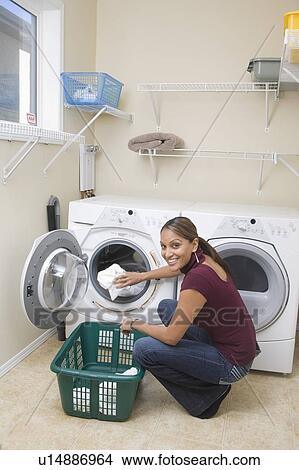 Picture - Woman loading front loading washing machine with cloth diapers, Winnipeg, Canada. Fotosearch