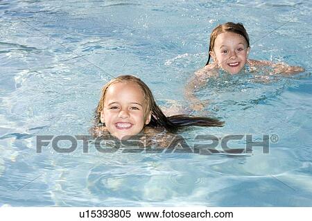 Stock Photography - 2 young girls swimming in a swimming pool, Jacksonville, Florida. Fotosearch