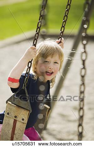 Stock Image - 4 Year Old Girl Playing on a Swing, Vancouver, B. C.. Fotosearch