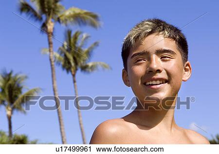 Stock Image - Boy under palm trees, Hawaii. Fotosearch
