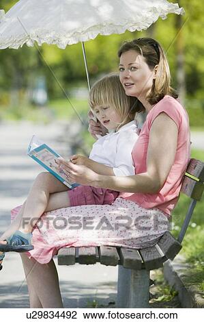 Caucasian Mom and 4 year old Daughter, reading a book on a park bench, Sunset Beach, Vancouver, B. C. View Large Photo Image Stock Image - Caucasian Mom and 4 year old Daughter, reading a book on a park bench, Sunset Beach, Vancouver, B. C.. Fotosearch