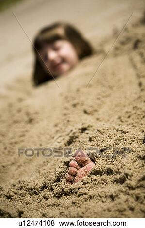Girl (4) buried to neck in sand with toe sticking out, Grand Beach Provincial Park, Manitoba, Canada View Large Photo Image Stock Photo - Girl (4) buried to neck in sand with toe sticking out, Grand Beach Provincial Park, Manitoba, Canada. Fotosearch