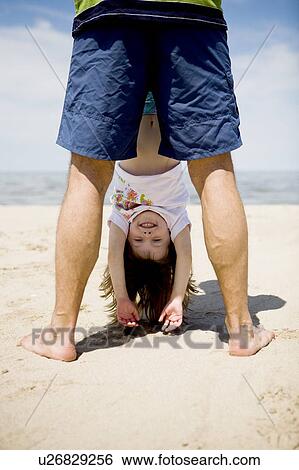 Stock Photograph - Girl is held upside down, Grand Beach Provincial Park, Manitoba, Canada. Fotosearch