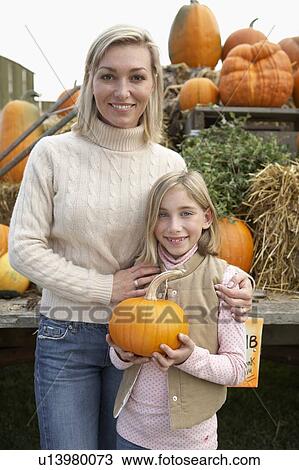 Mother with daughter holding organic pumpkin, Ladner, British Columbia, Canada View Large Photo Image Stock Image - Mother with daughter holding organic pumpkin, Ladner, British Columbia, Canada. Fotosearch