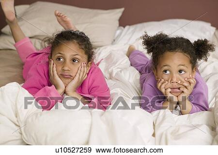 Stock Photo - Mulatto sisters in bed. 3 and 6 years old.. Fotosearch