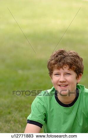 Stock Image - Portrait of young guy on grass, Regina, Saskatchewan. Fotosearch