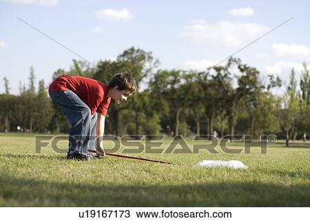 Stock Image - Six year old boy with butterfly net in park, Assiniboine Park, Winnipeg, Canada. Fotosearch