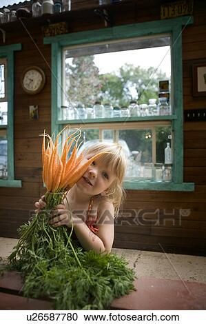 Young girl holds garden fresh carrots, Lumsden, Saskatchewan, Canada View Large Photo Image Stock Image - Young girl holds garden fresh carrots, Lumsden, Saskatchewan, Canada. Fotosearch