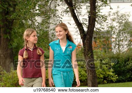 Stock Image - Young girls walking down street, Regina, Saskatchewan. Fotosearch
