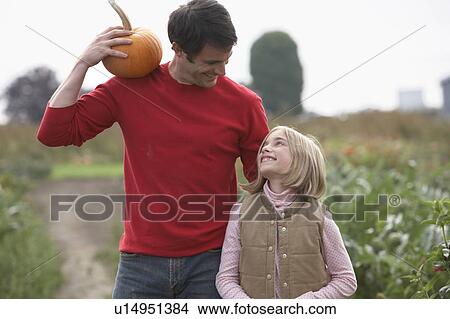 Father and daughter with organic pumpkins walking in farm fields, Ladner, British Columbia View Large Photo Image Picture - Father and daughter with organic pumpkins walking in farm fields, Ladner, British Columbia. Fotosearch
