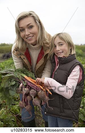 Mother and daughter at an organic farm with fresh vegetables, Ladner, British Columbia, Canada View Large Photo Image Stock Photography - Mother and daughter at an organic farm with fresh vegetables, Ladner, British Columbia, Canada. Fotosearch