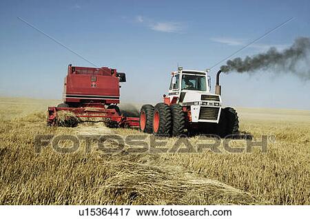 Stock Photo - Tractor Pulls Combine. Fotosearch