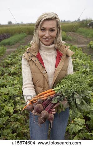 Picture - Woman with a bundle of fresh organic vegetables, Ladner, British Columbia, Canada. Fotosearch