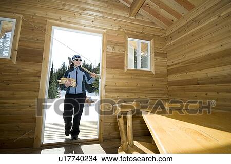 A Woman Brings Firewood Into A Warming Hut After Cross Country